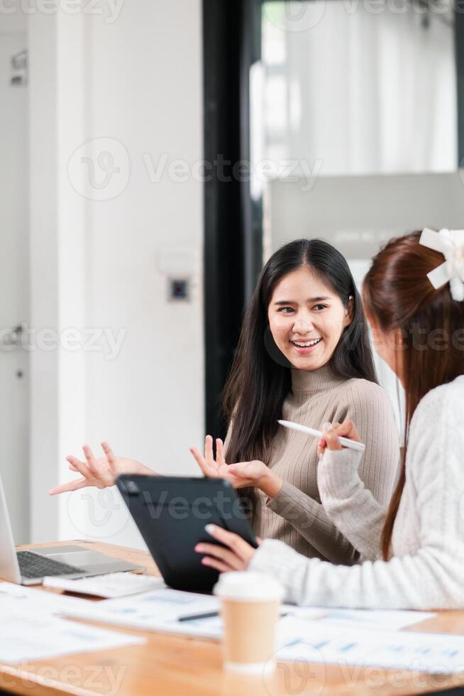 Two young professionals discussing ideas in a bright, modern office environment, showcasing teamwork and collaboration. photo