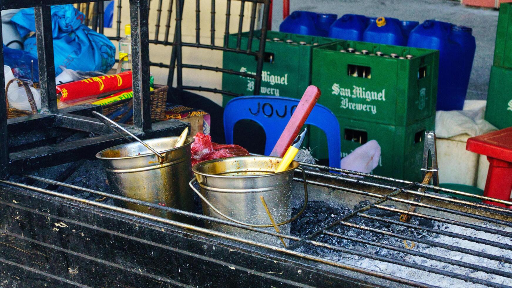 a grill with metal buckets with sauce and oils inside photo