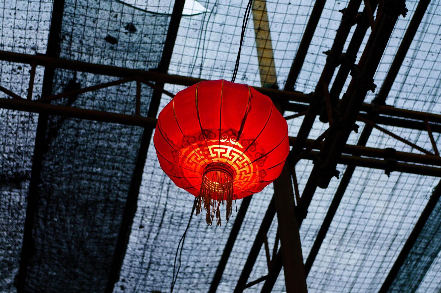 a red lantern hanging from a ceiling photo