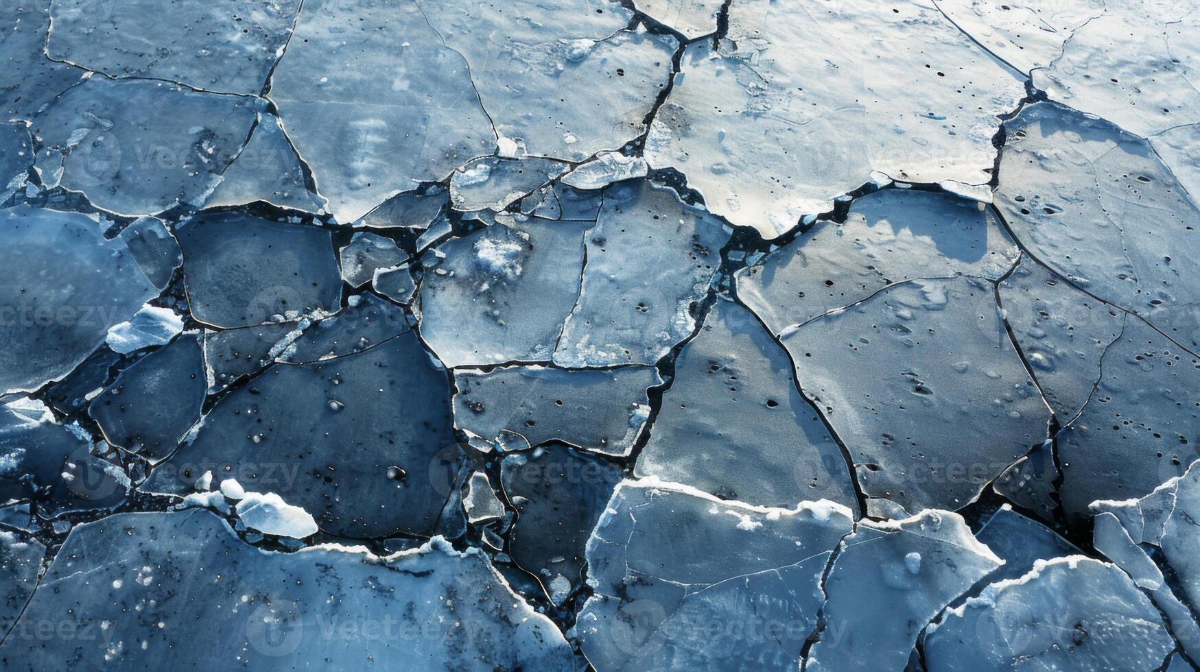 Fragments of thick ice lie scattered on the surface of a frozen lake, reflecting light and creating intricate patterns under the winter sun. photo