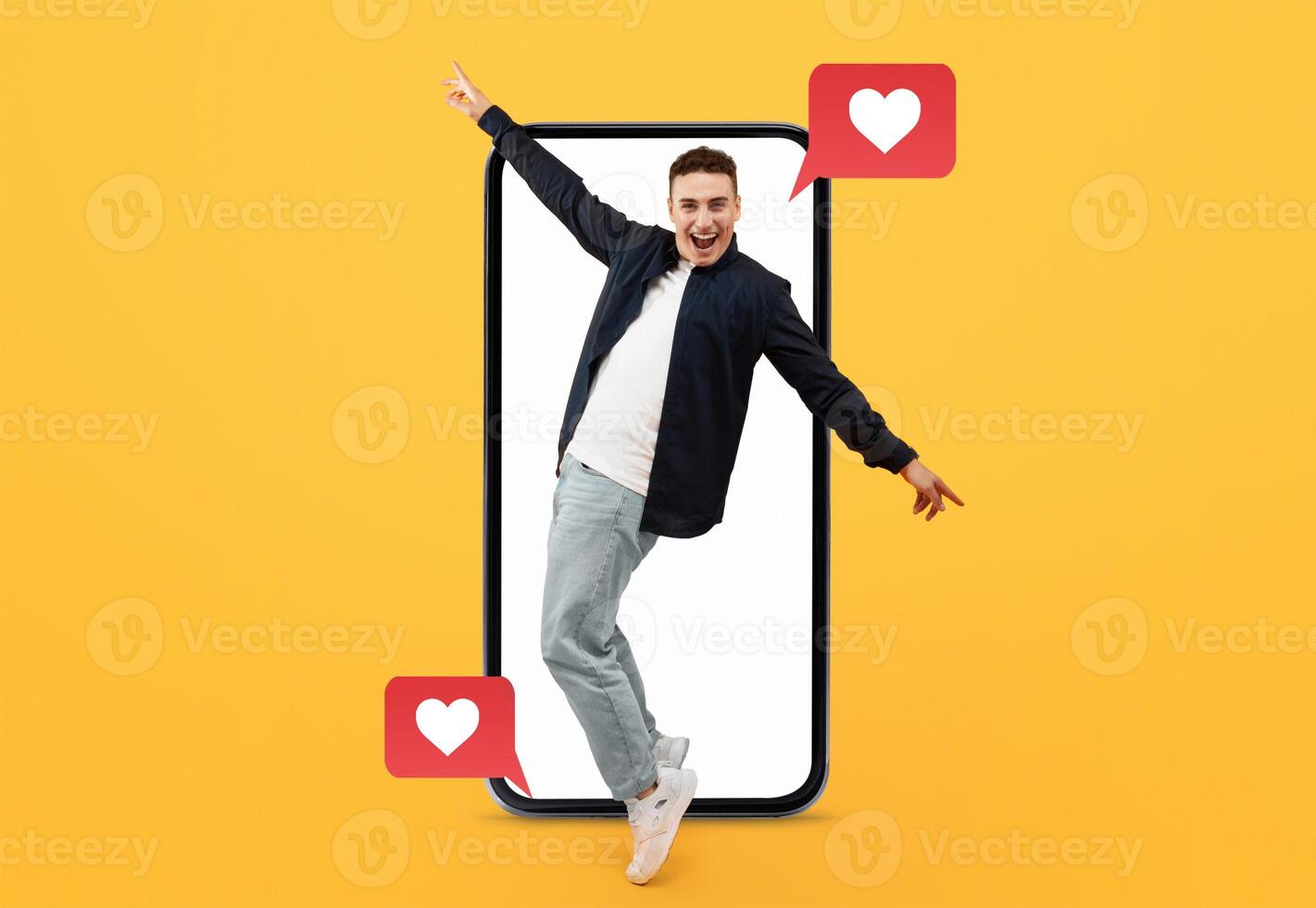A young man joyfully interacts with his smartphone, surrounded by social media icons symbolizing love. This vibrant setup captures the essence of modern dating and digital communication. photo