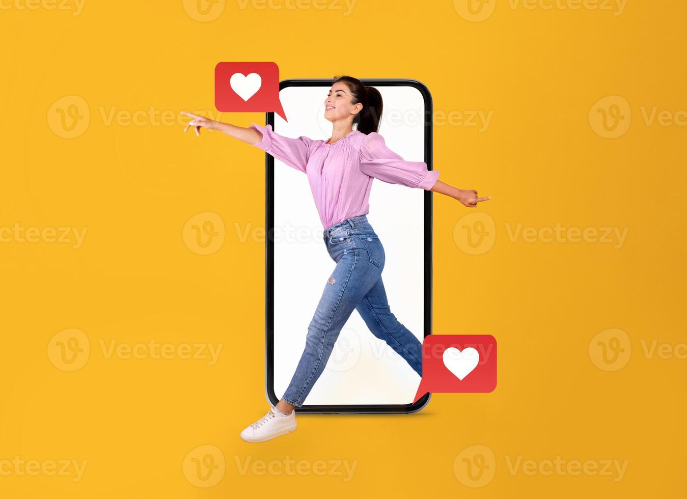 A person interacts joyfully with a smartphone, expressing excitement for communication. The vibrant yellow background highlights themes of love and connection through modern technology. photo