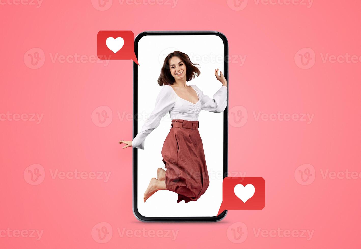 A joyful person leaps within a smartphone, surrounded by heart icons, symbolizing love and connection during Valentine's Day. The vibrant backdrop enhances the theme of romance and social interaction. photo