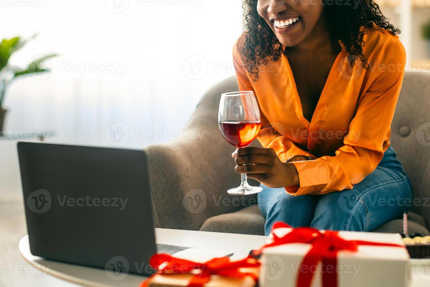 Online Birthday Concept. Black Lady Toasting To Laptop Celebrating B-day Having Call Sitting In Front Of Computer And Drinking Wine At Home. Virtual Party, Modern Holiday Celebration photo