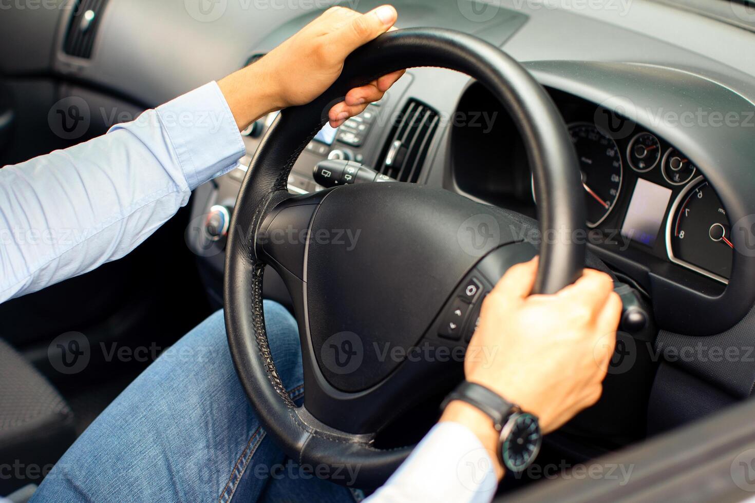Unrecognizable businessman driving new comfy automobile, holding hands on steering wheel, top view. Cropped of driver sitting inside nice brand new car. Safety driving concept photo