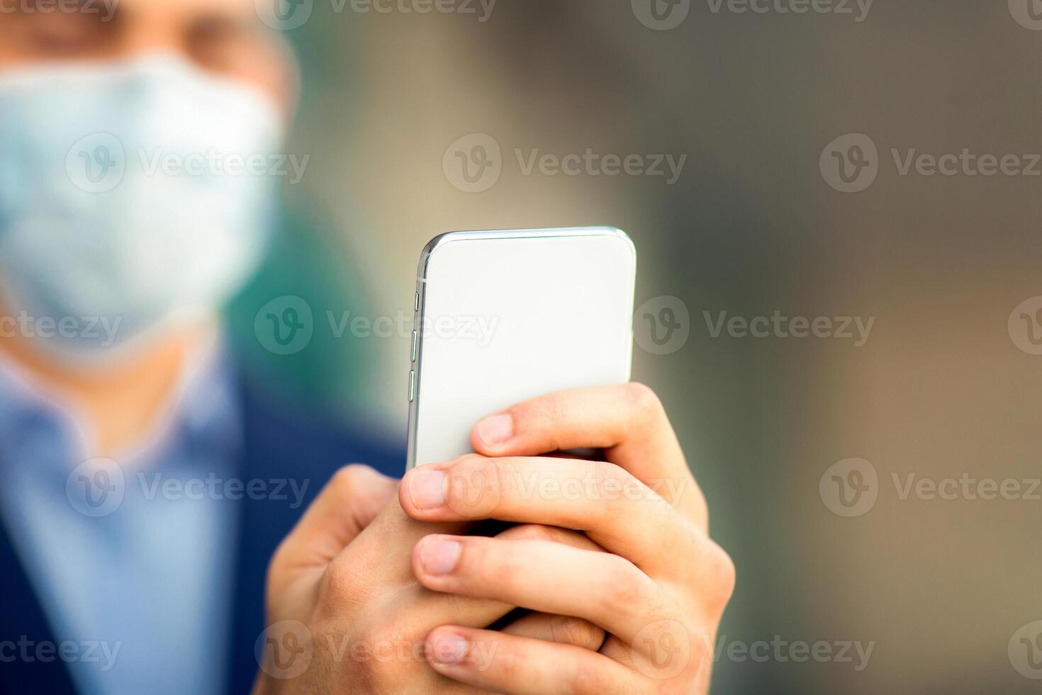 Modern smartphone in arabic businessman hands, man wearing protective face mask, entrepreneur, independent contractor working online while COVID-19 pandemic, copy space. Technologies in business photo