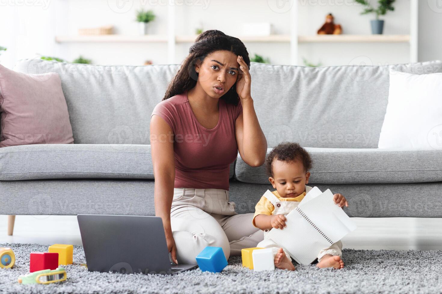Working At Home Problems. Stressed Mother Trying To Work On Laptop While Baby Distracting Her, Worried African American Woman Having Troubles With Remote Work While Taking Care About Child photo