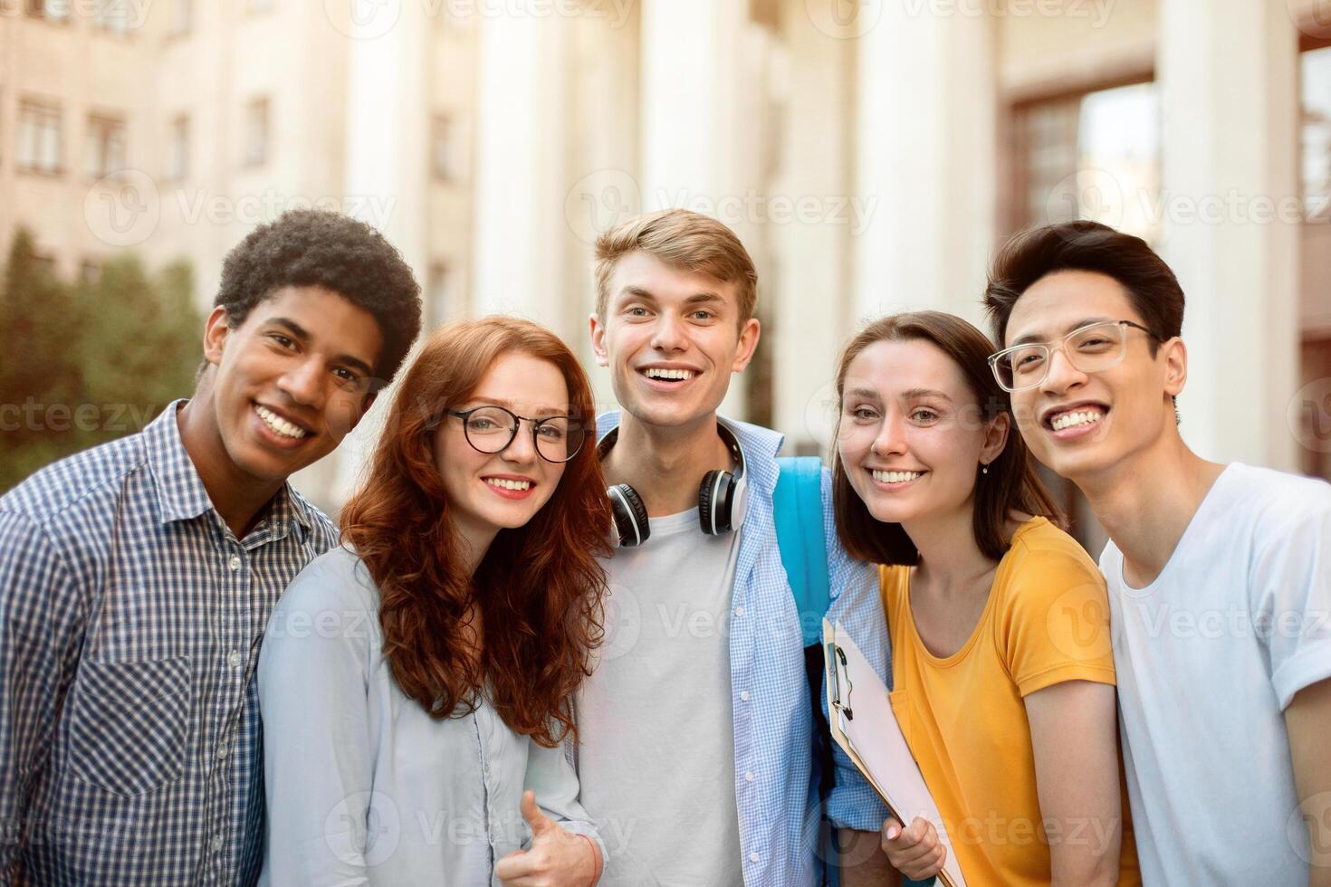 Group Of Joyful Multiethnic Students Posing Smiling To Camera Standing Near College Building Outside. Higher Education Concept photo