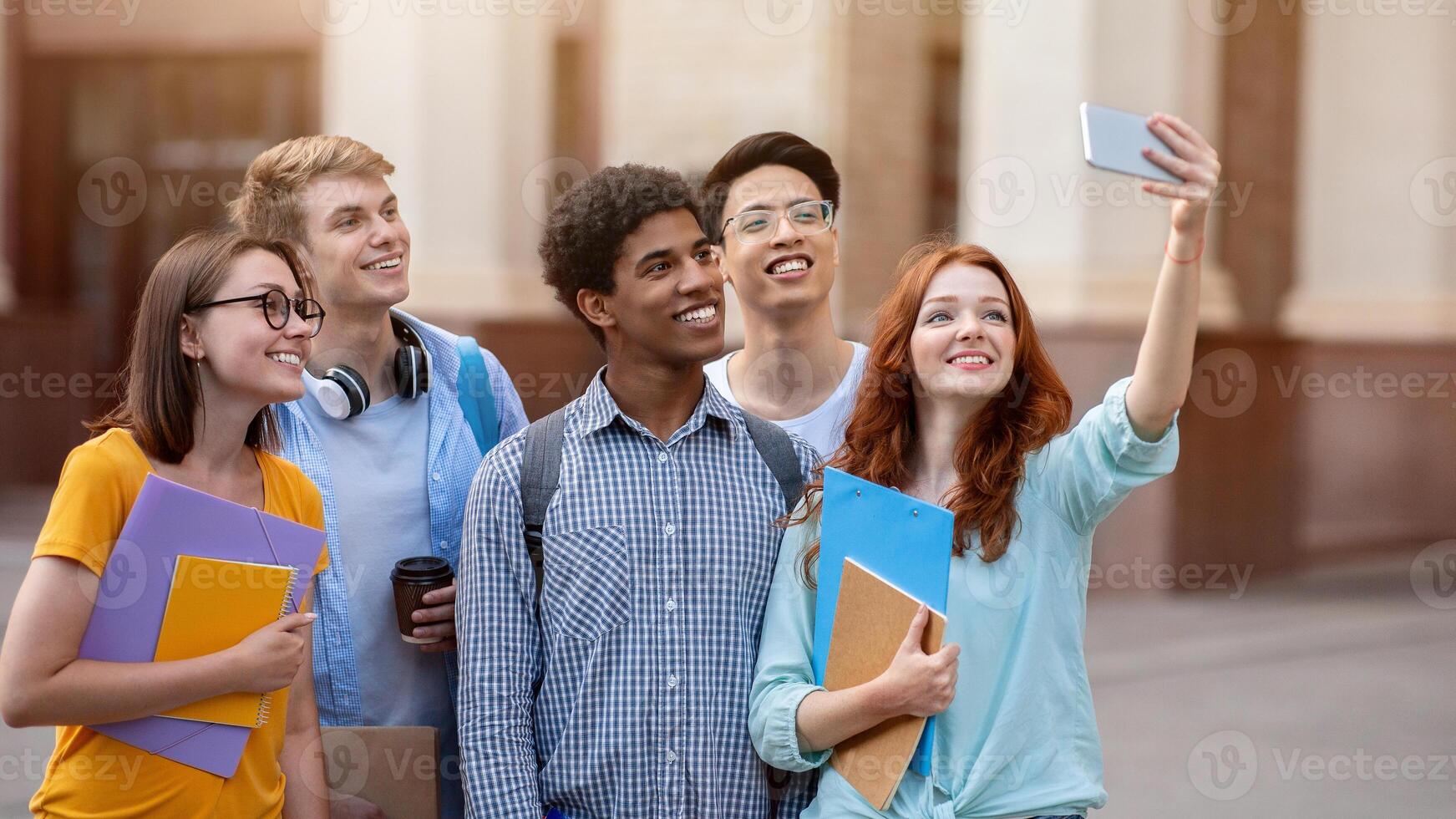 Happy Student Girl Making Group Selfie With Coursemates On First Day Of Study At University Standing Outdoor. photo
