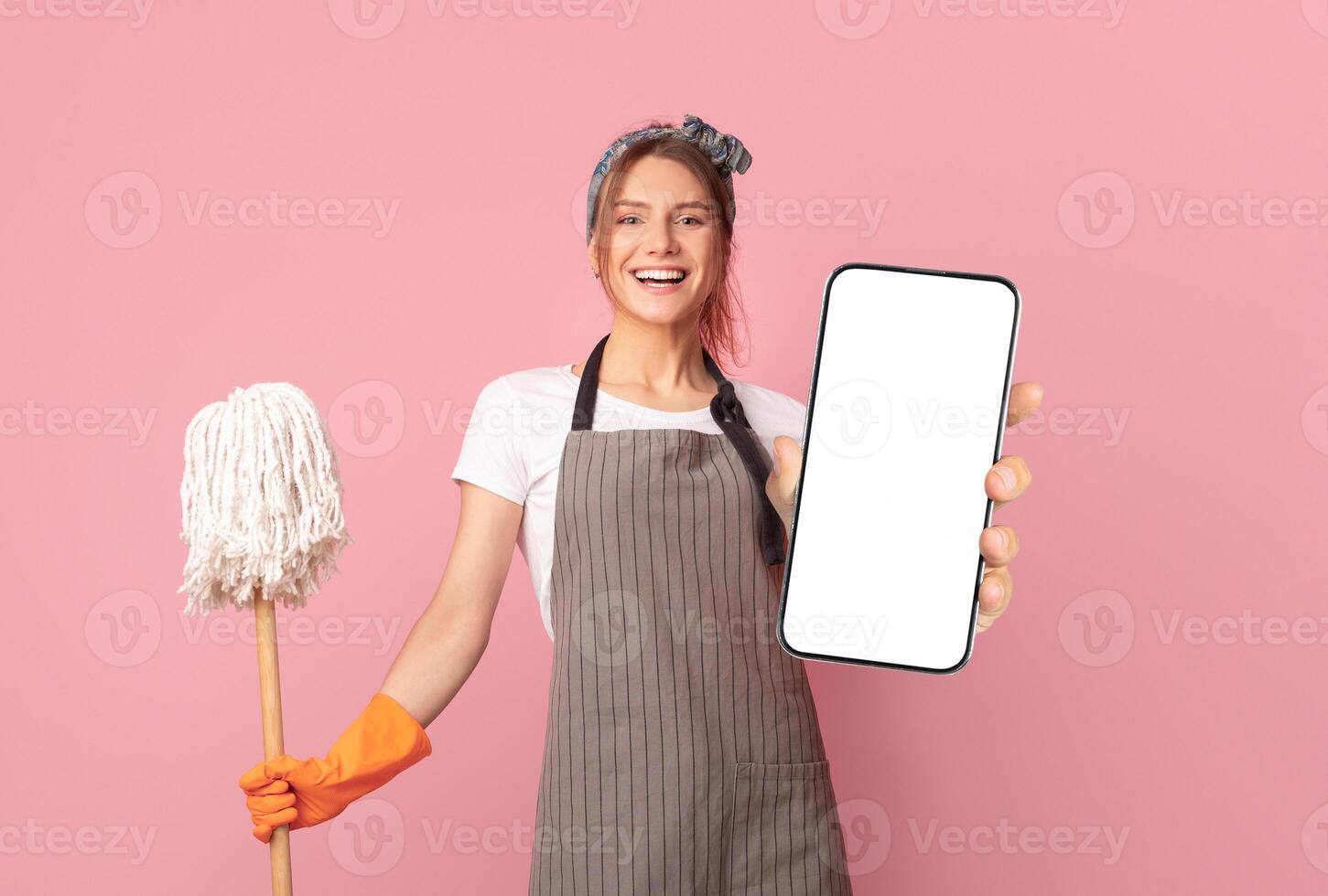 Household Duties. Cheerful Young Woman With Mop And Cleaning Supplies Posing Over Pink Background In Studio, Free Space photo