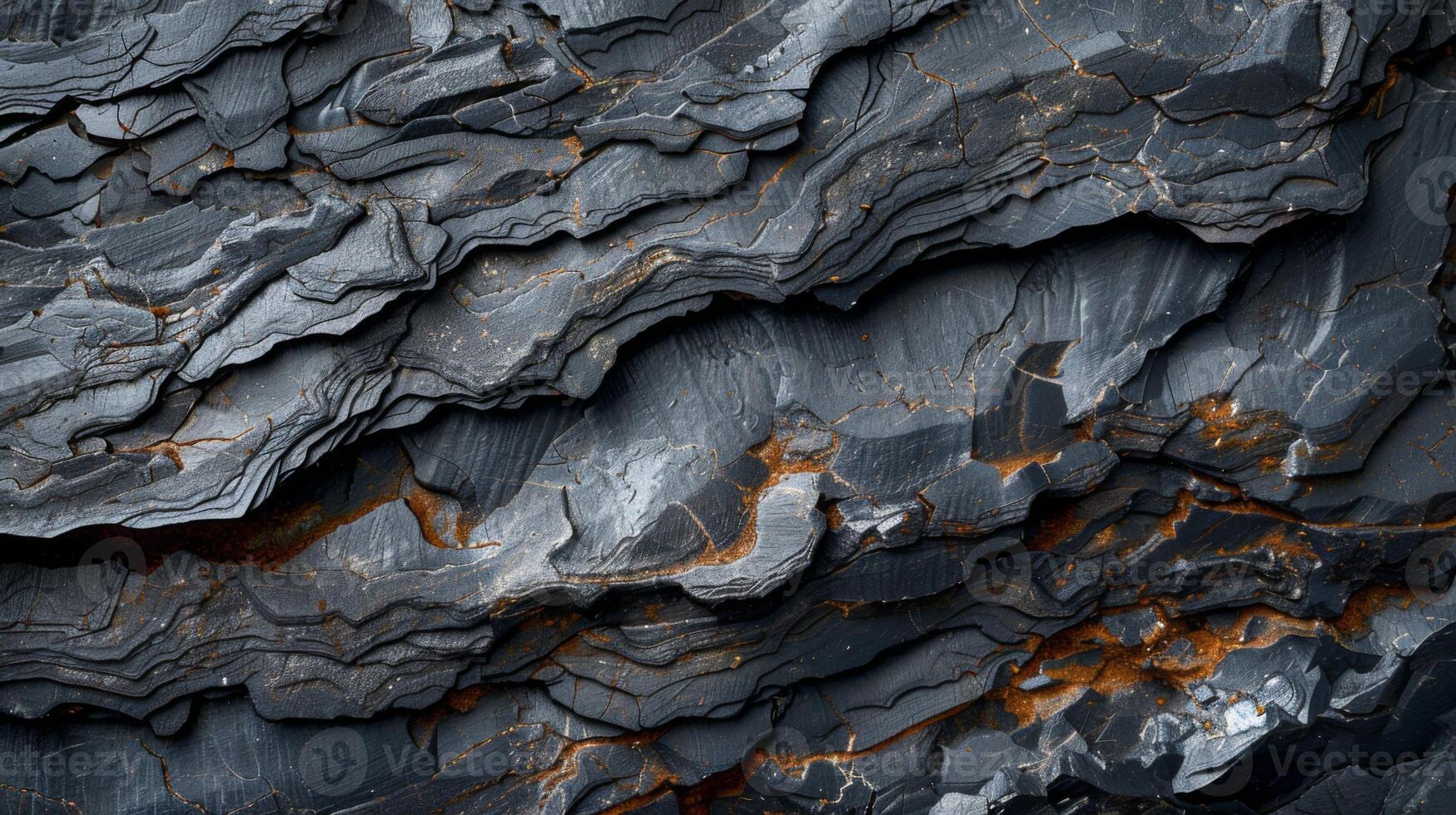 Intricate dark rock formations display unique textures and layered patterns, showcasing natural beauty through varying shades of gray and hints of rust, inviting exploration and study. photo