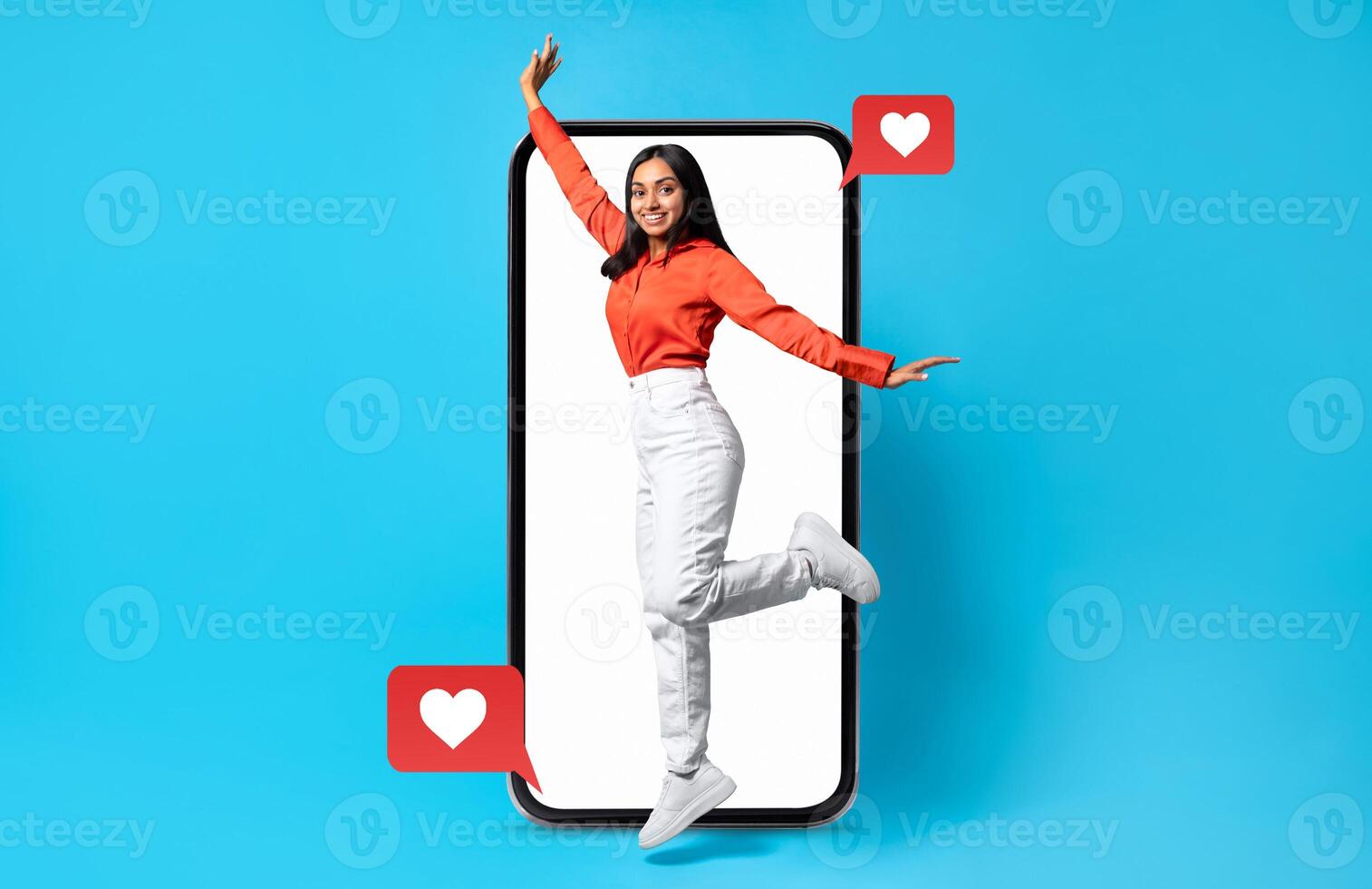 A person joyfully interacts with a smartphone displaying social media notifications, conveying themes of love and connection. The vibrant colors and heart symbols highlight Valentine's spirit. photo