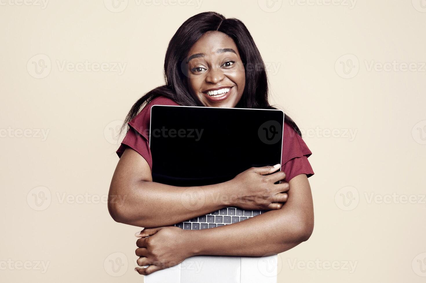 Delighted young african american woman hugging gadget and smiling, enjoying her brand new modern laptop, studio background, copy space. Computer, notebook, laptop, gadgets, modern technologies concept photo