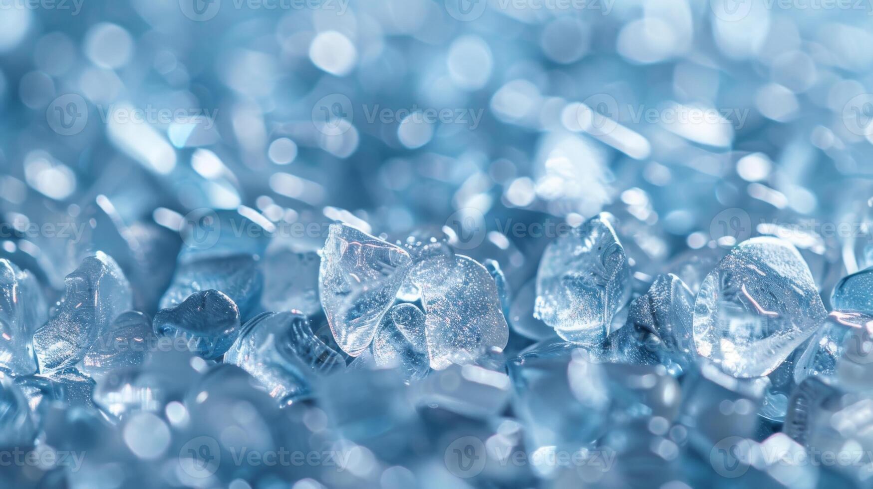 Shimmering blue glass fragments are scattered across a surface, reflecting light and creating a textured pattern. The close up view highlights the intricate details and clarity of the pieces. photo