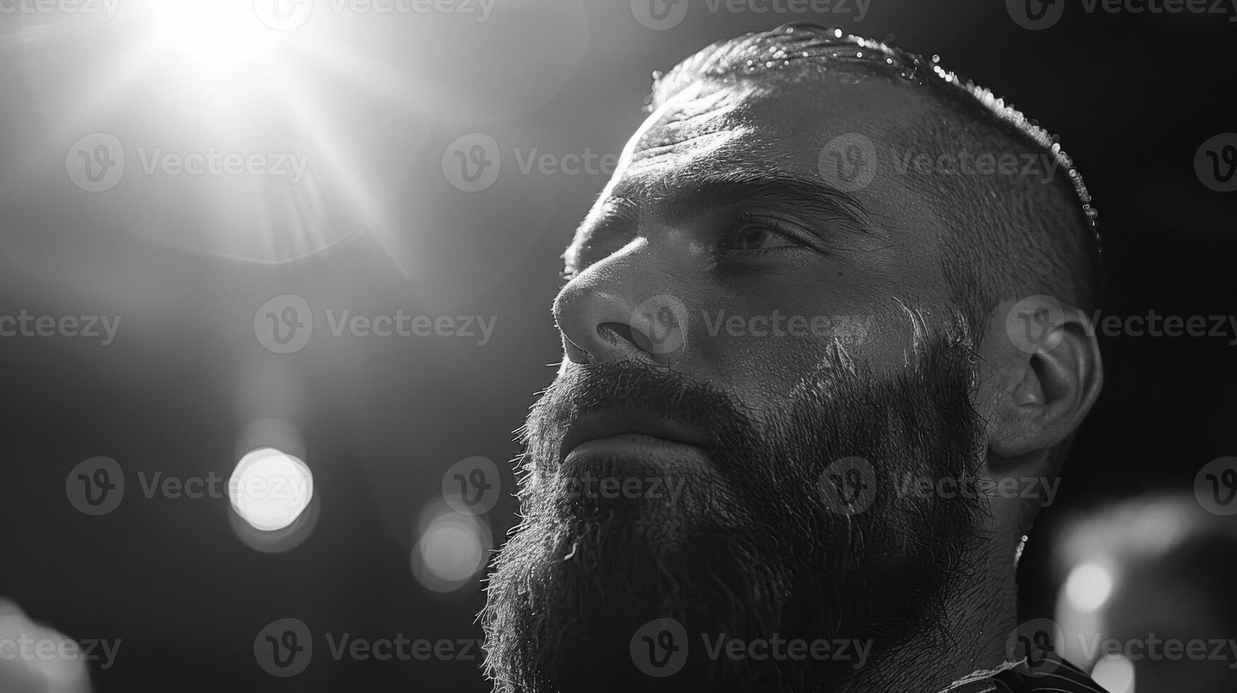 A man sits in a barber chair with a focused expression while receiving grooming services. Bright lights illuminate the elegant barbershop atmosphere. photo