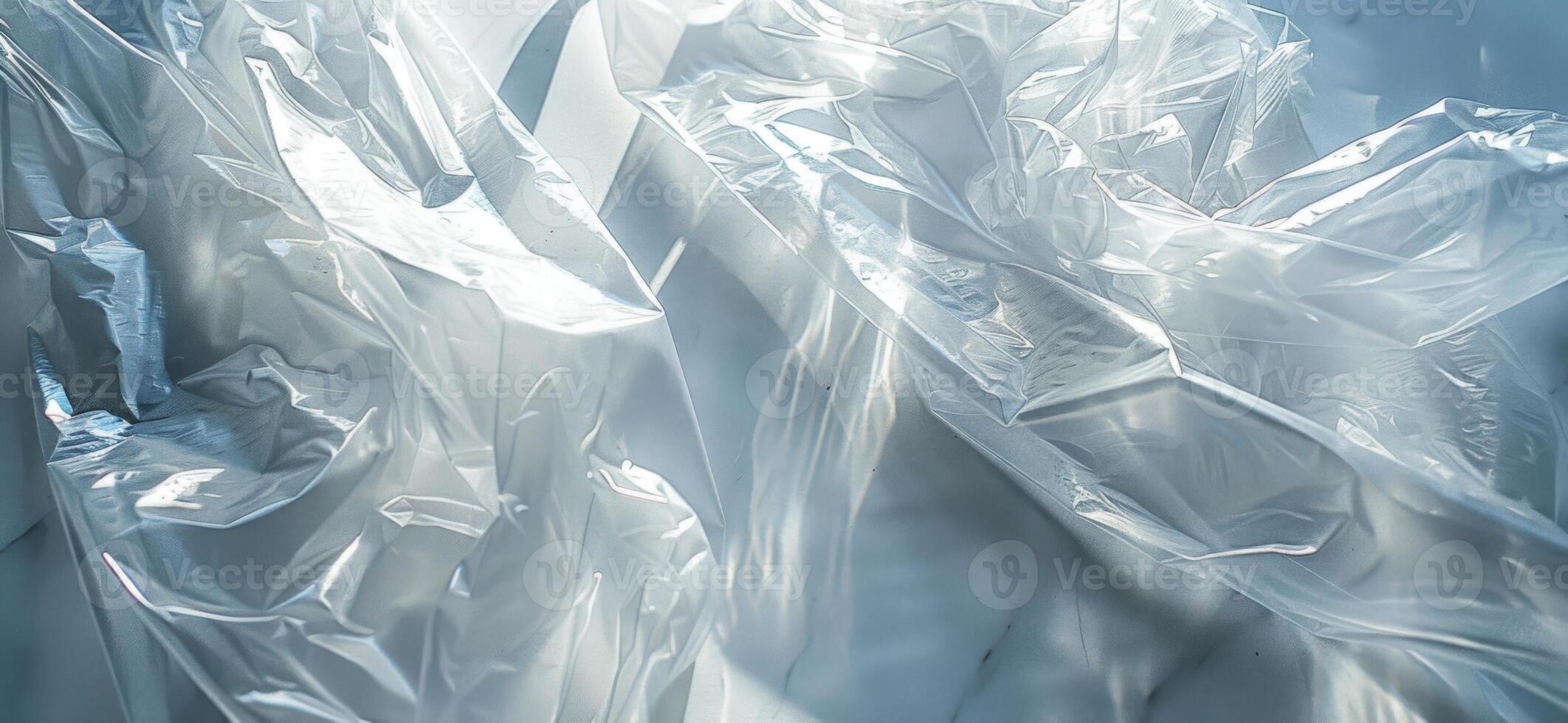 Wrinkles and folds in clear plastic sheets interact with natural light, creating fluid shapes and illuminating the surrounding area in a bright indoor space. photo