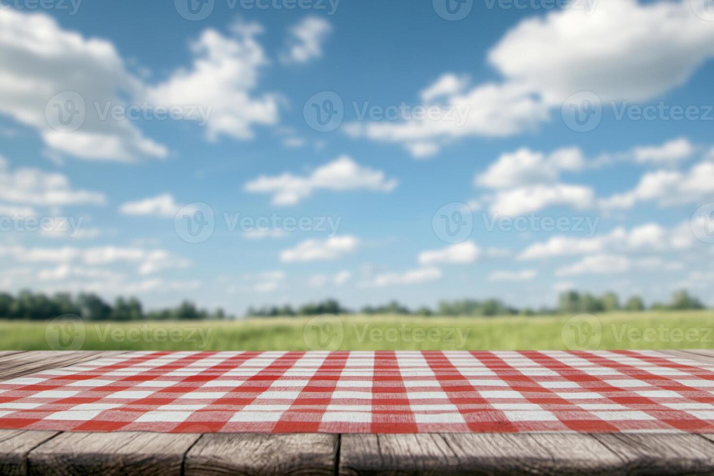 A picnic tablecloth on a wooden surface with a scenic sky background. photo