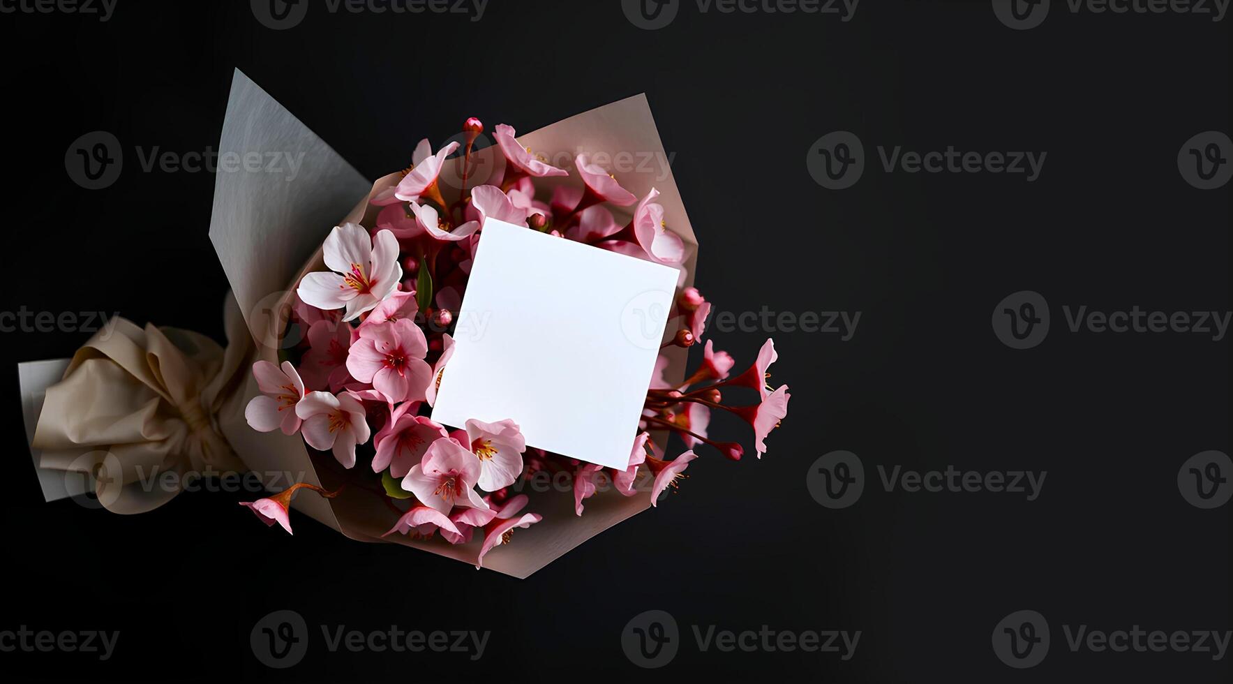 A bouquet of cherry blossom flower wrapped with a packet on dark background and a blank white greeting card is attached on it photo
