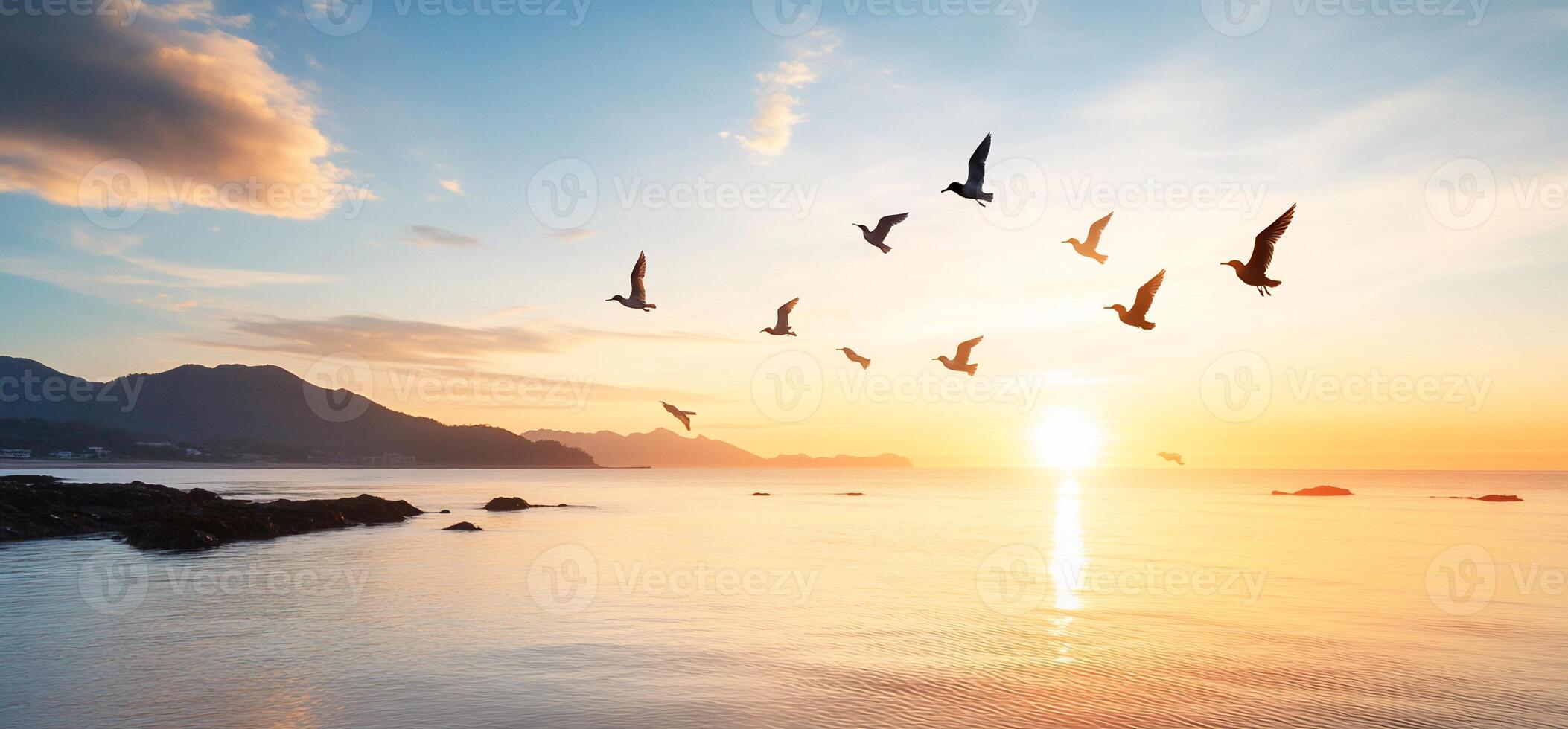 A serene sunset over water with birds flying in the sky. photo