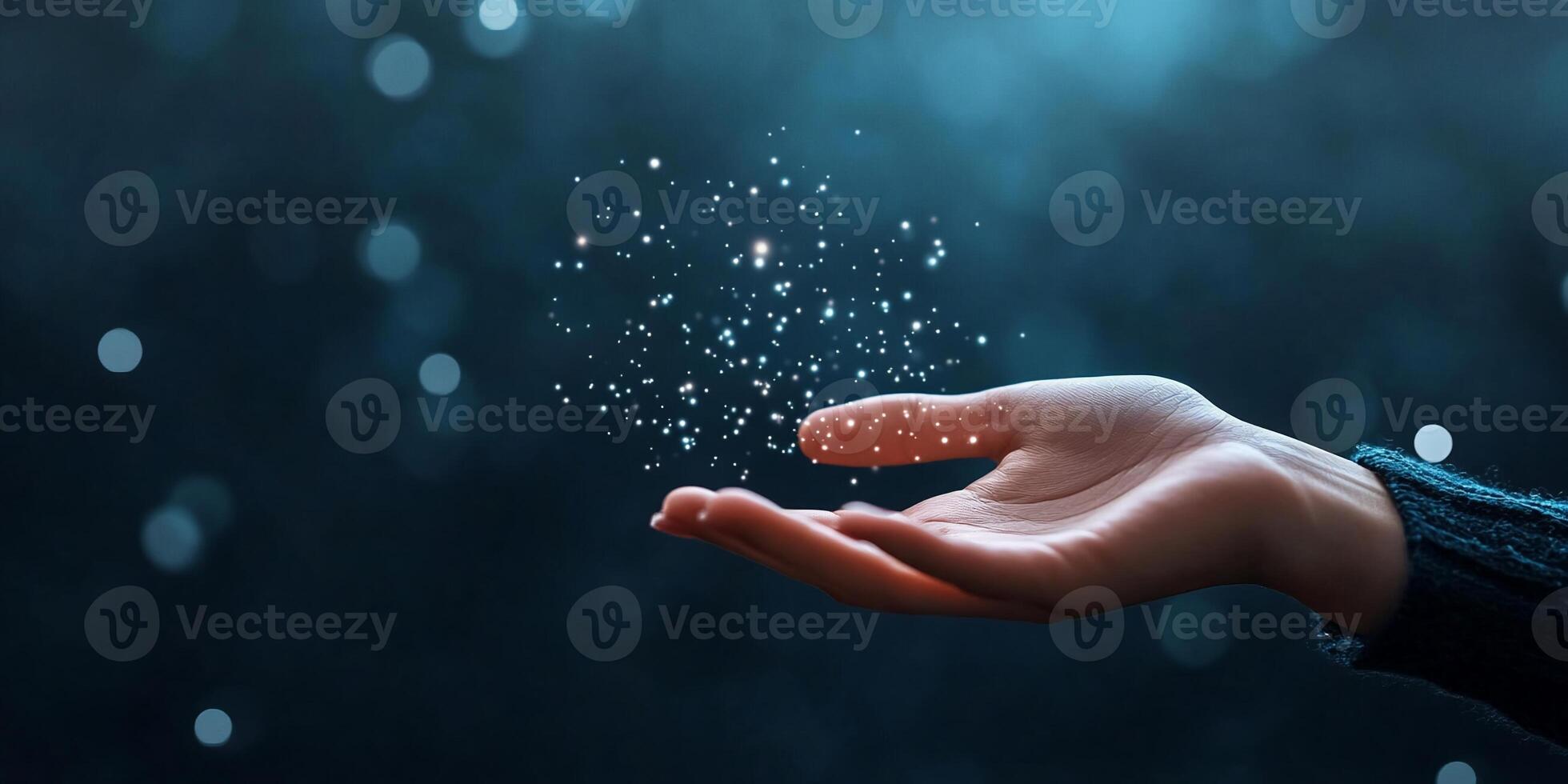A hand releasing sparkling particles in a dreamy blue atmosphere. photo
