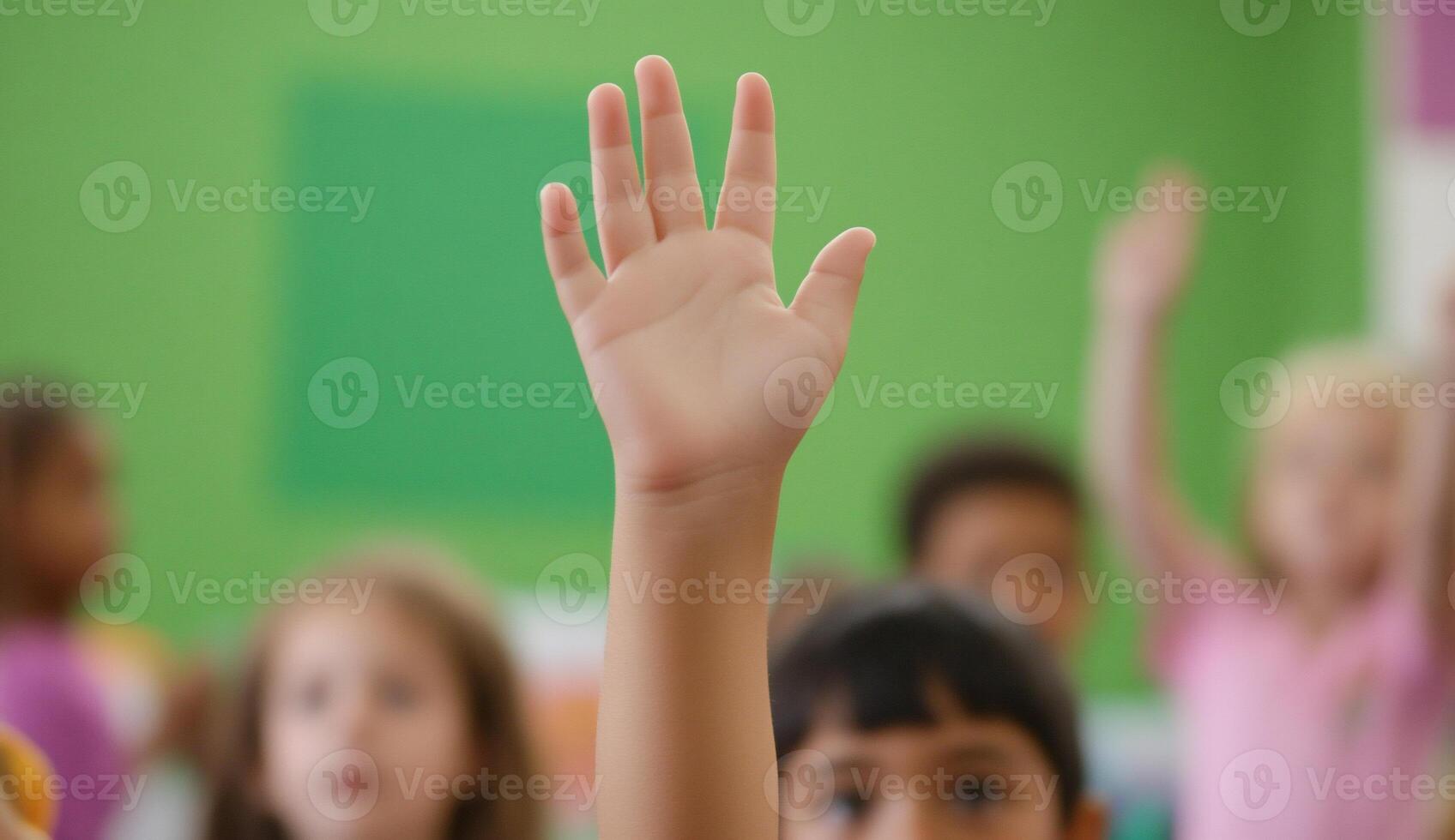 A child's raised hand in a classroom setting, indicating participation. photo