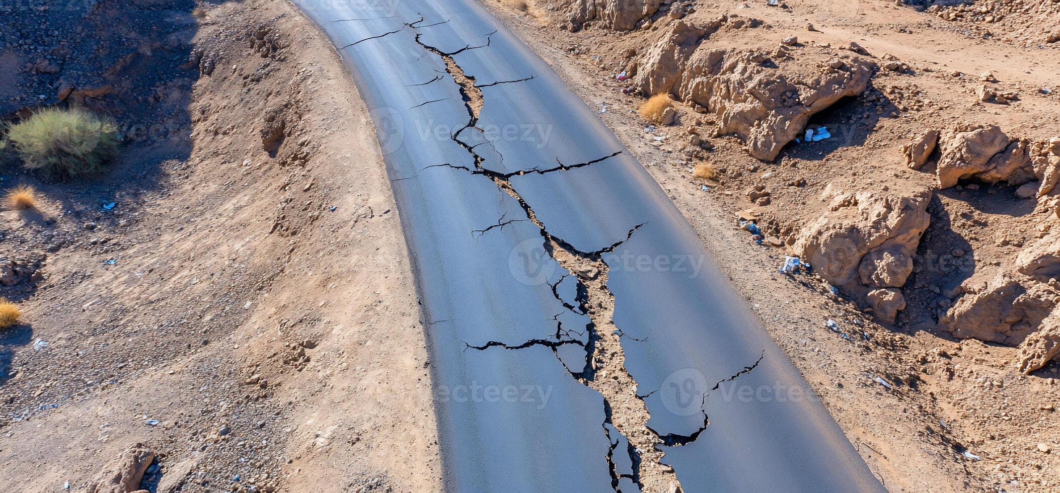 A cracked road in a dry landscape, indicating geological activity. photo