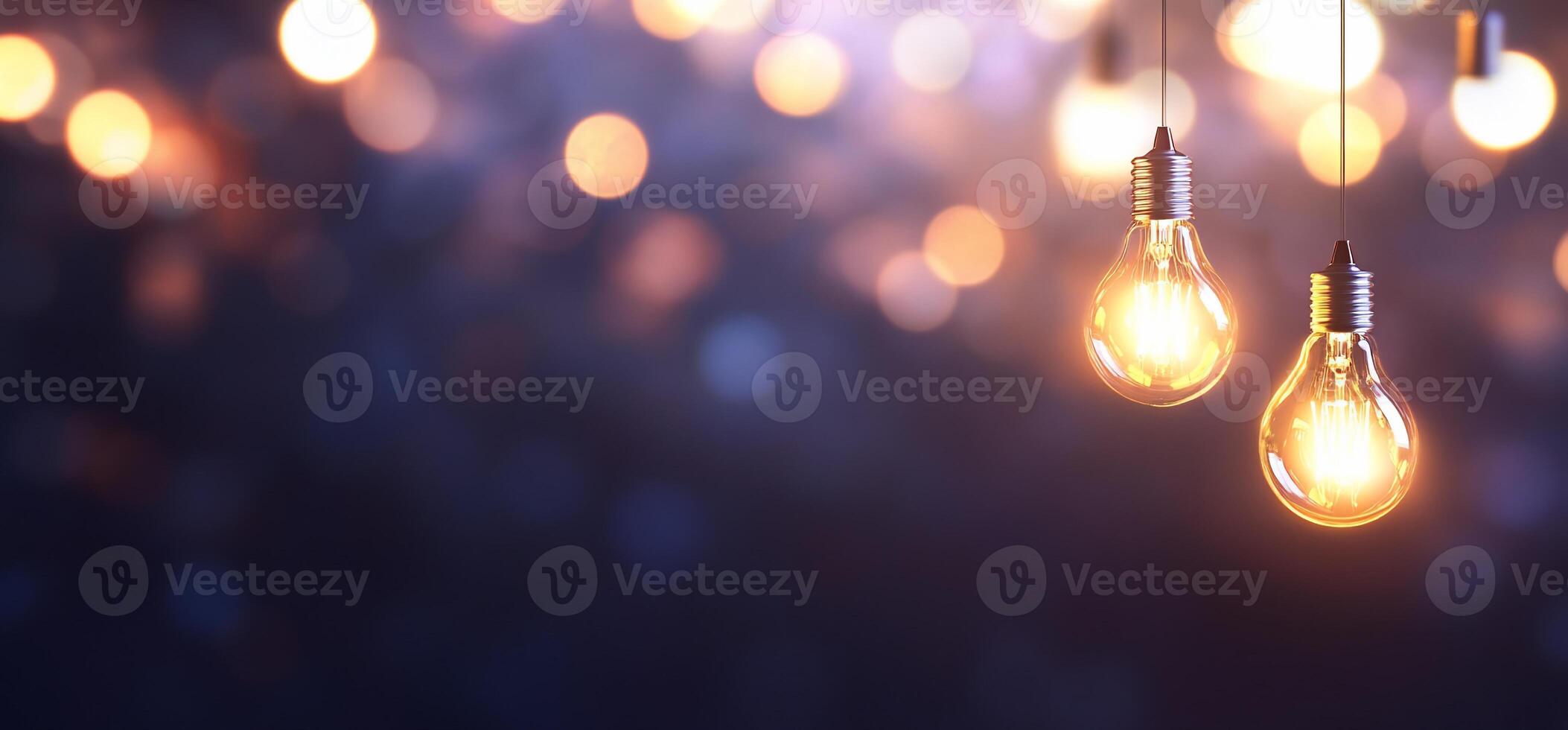 Two glowing light bulbs against a blurred background of warm lights. photo