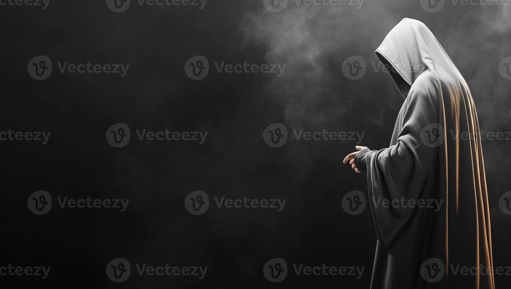 A cloaked figure stands in a dark, misty environment, evoking mystery. photo