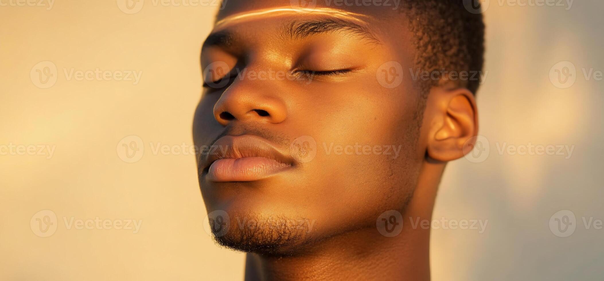 A serene portrait of a young man with closed eyes in soft lighting. photo