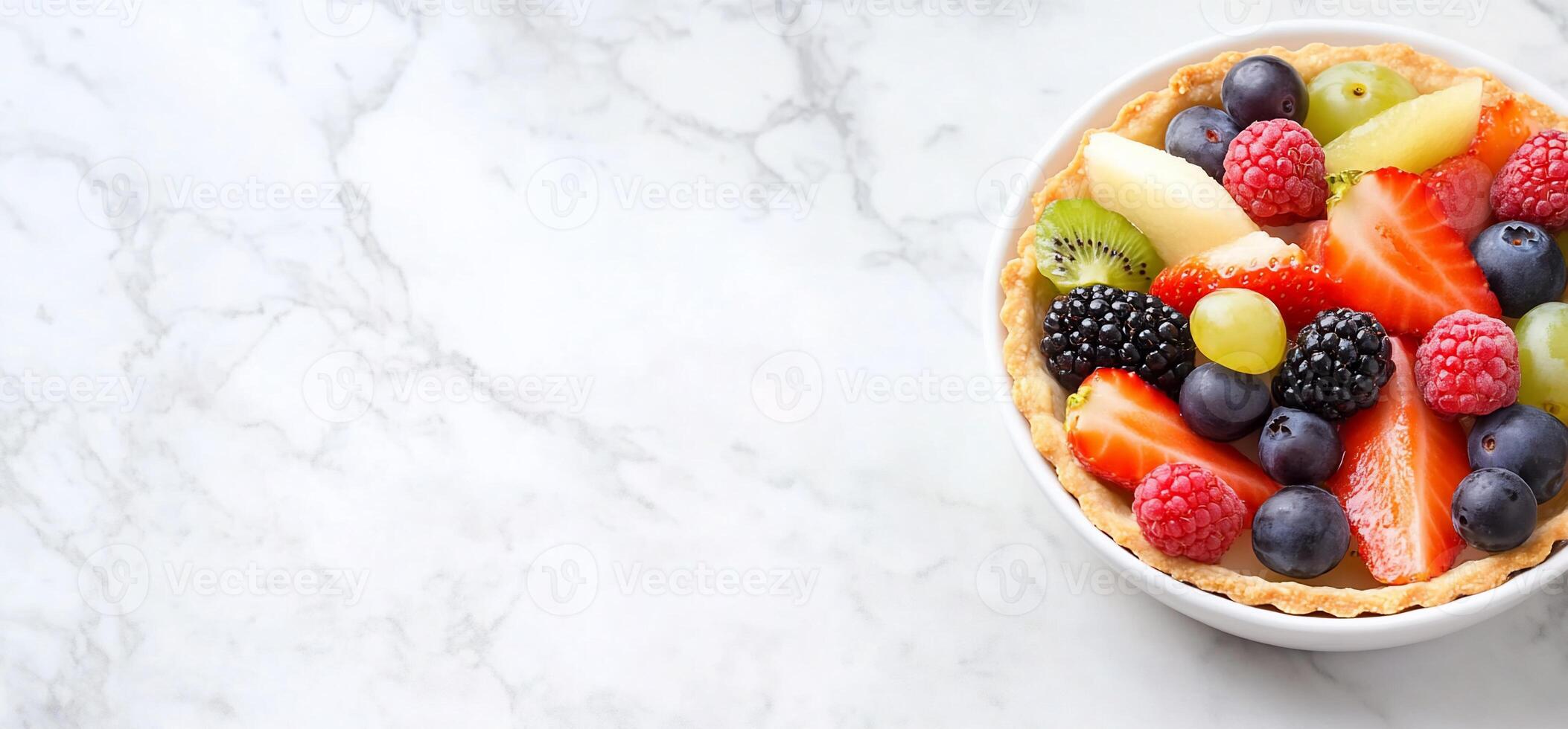 A colorful fruit tart topped with various fresh fruits in a bowl. photo