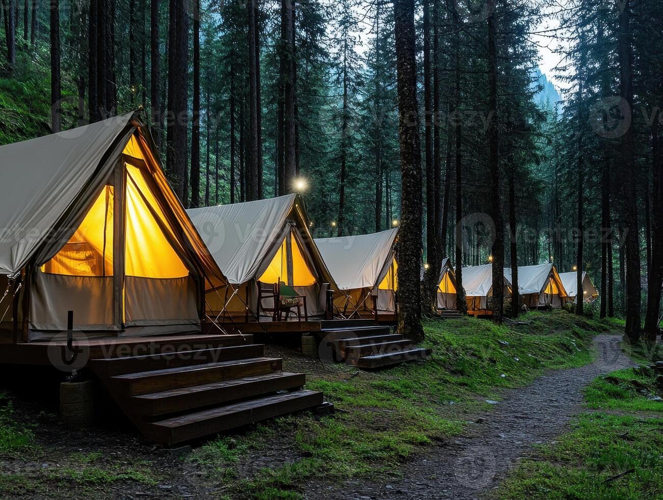 Glamping tents illuminated at dusk, nestled among tall trees in a serene forest setting, inviting outdoor enthusiasts to enjoy nature comfortably. photo