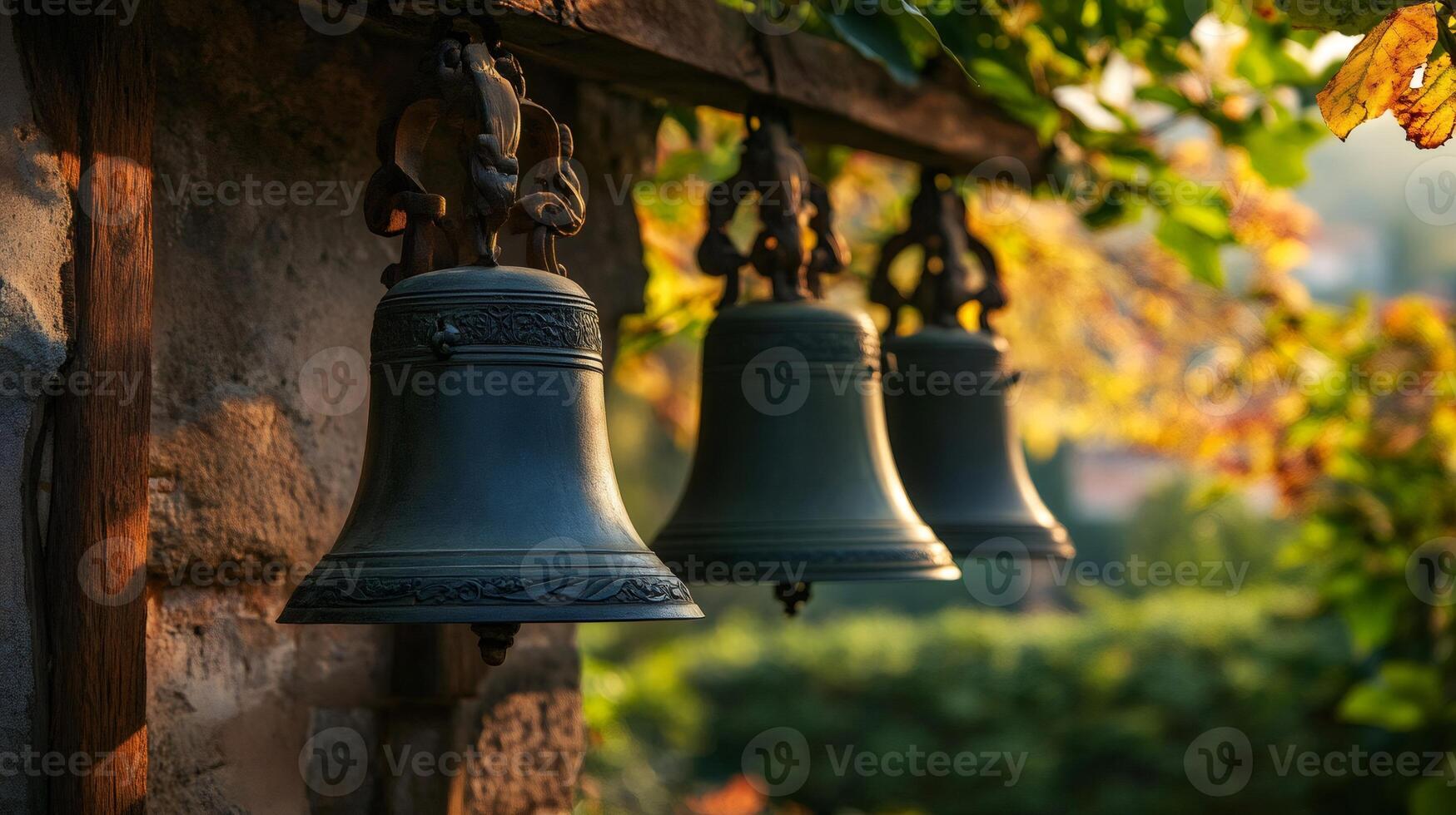 Old bells hanging on wooden beam in autumnal garden photo