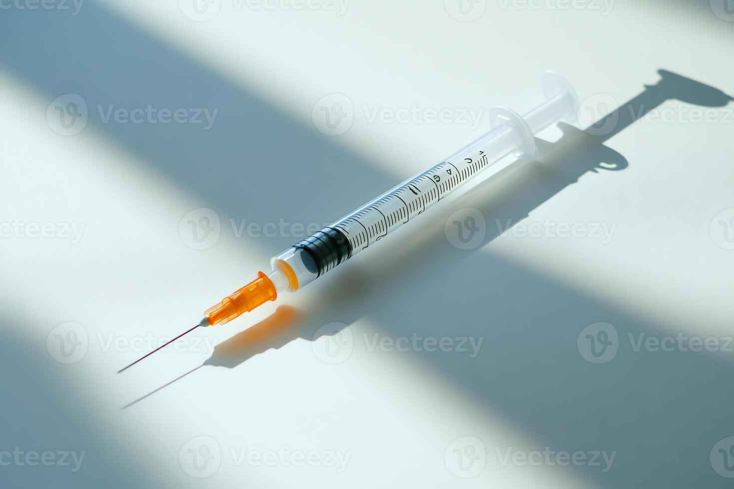 Medical syringe casting a shadow on a white surface photo