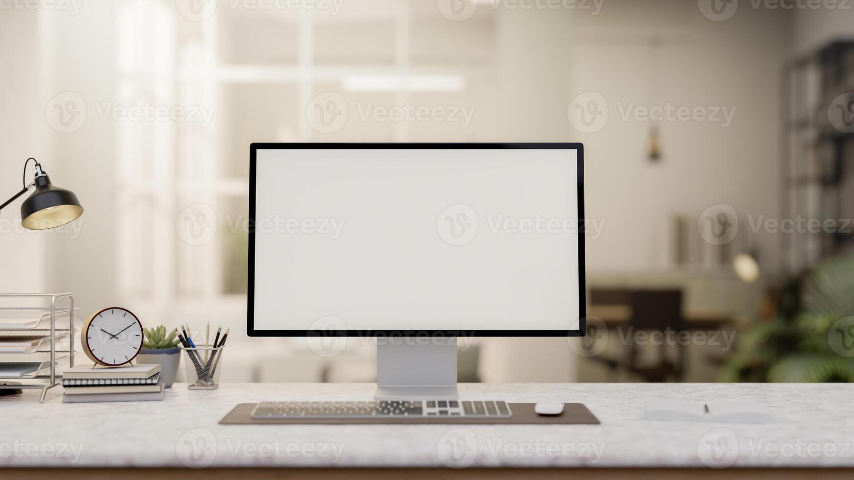 A computer with a white screen mockup and decorative items on a white desk set in a modern office. photo