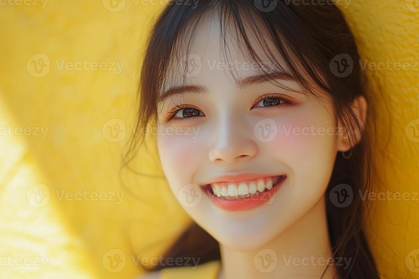 A woman smiling in front of a yellow wall photo