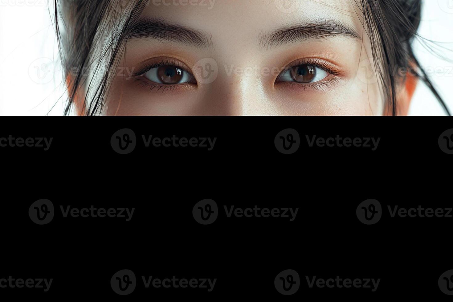 A woman with brown eyes peeking out from behind a black curtain photo