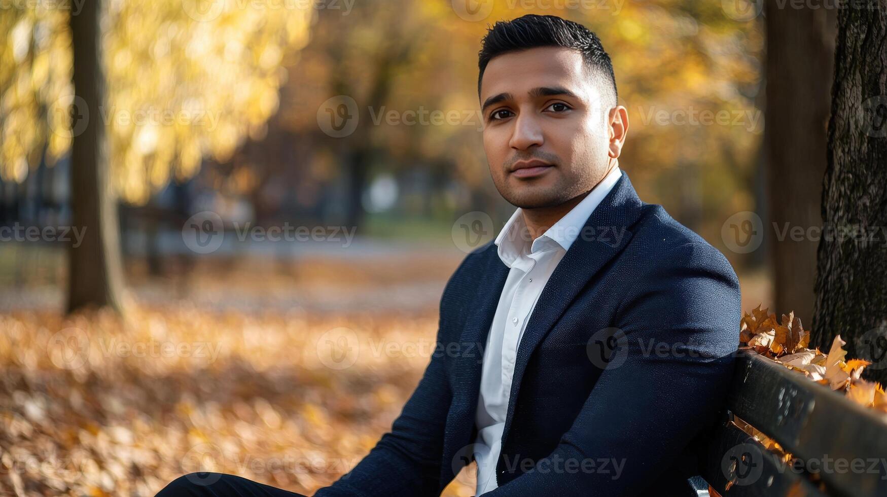 Young Man Sitting On Park Bench Autumn Leaves photo