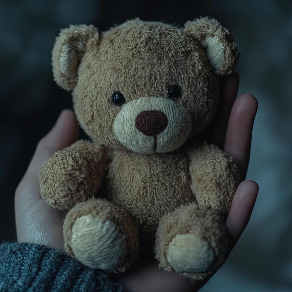Hand holding teddy bear photo
