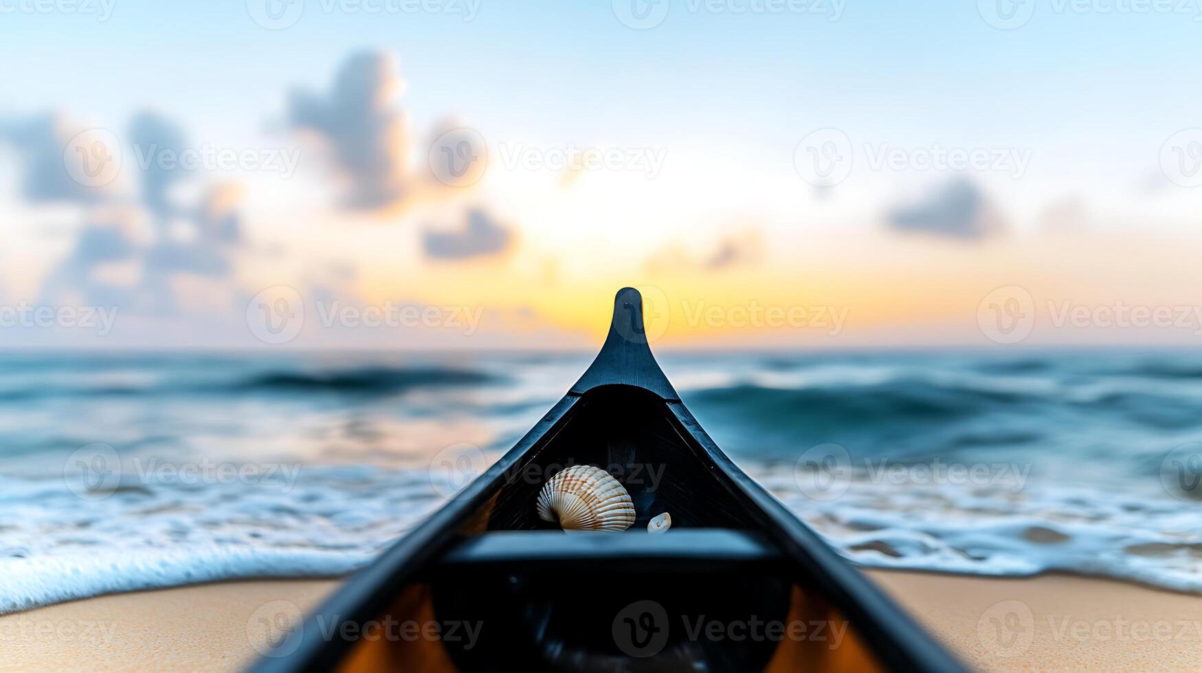 A serene sunset view from a kayak on a tranquil beach, featuring a seashell in the foreground photo