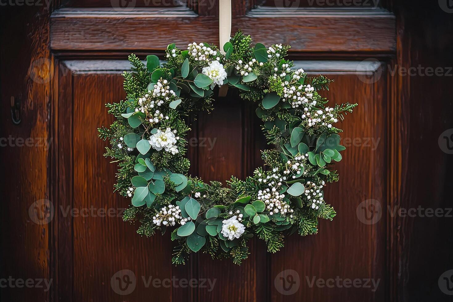 vibrant wreath made of fresh green foliage and delicate white flowers is beautifully showcased against dark wooden door illuminated warm natural light photo