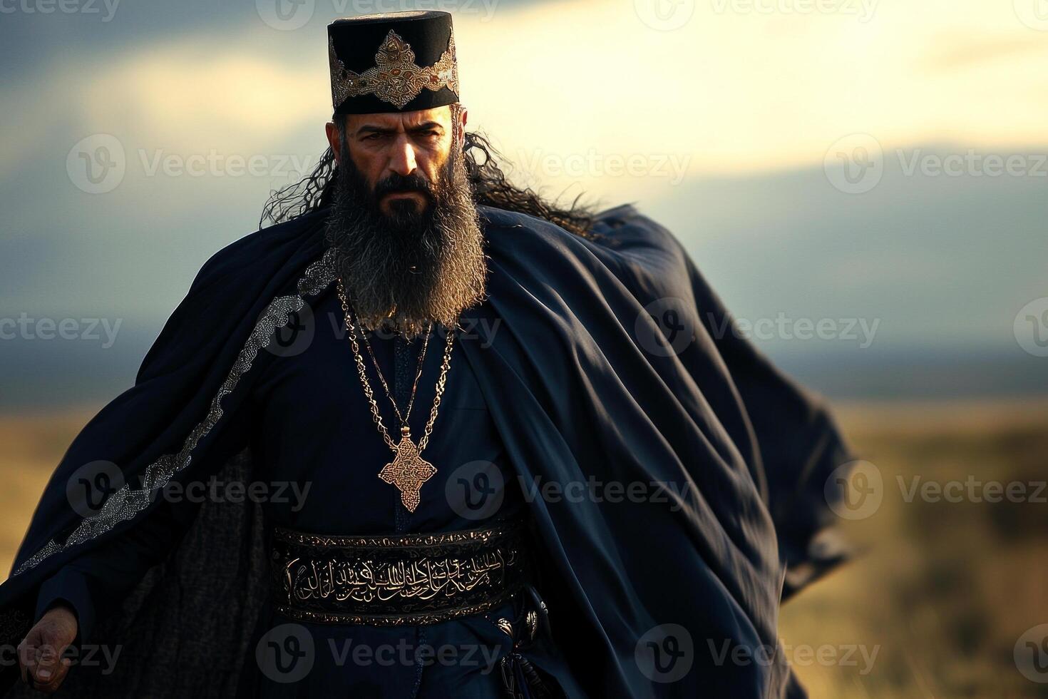 man in dark blue jubba and taqiyah cap stands in expansive desert surrounded soft winds lift his robe. moment captures spirit of Eid al Fitr photo