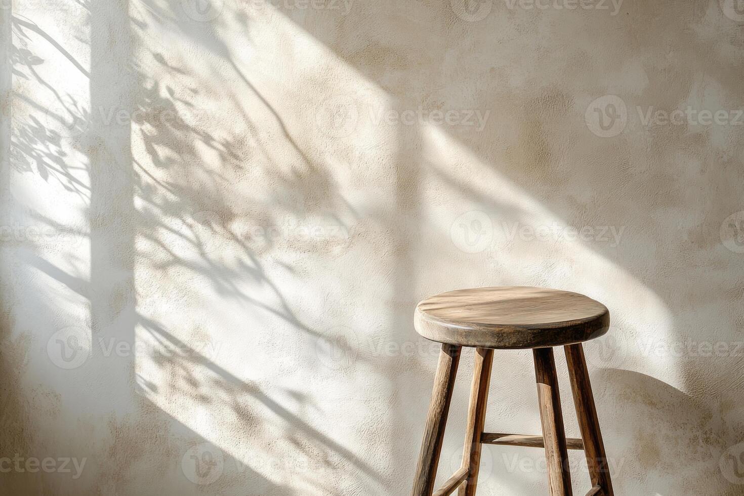 A wooden stool casts soft shadows against a textured wall, enhanced by warm, natural light. photo