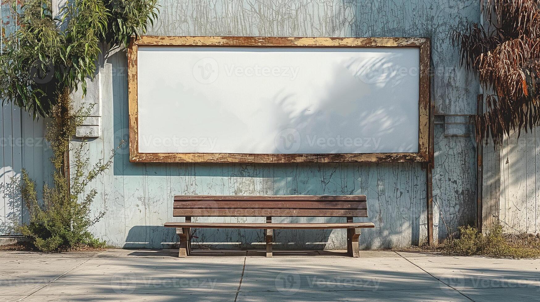 A weathered wooden bench sits in front of a blank billboard against a vintage blue wall, evoking a sense of nostalgia. photo