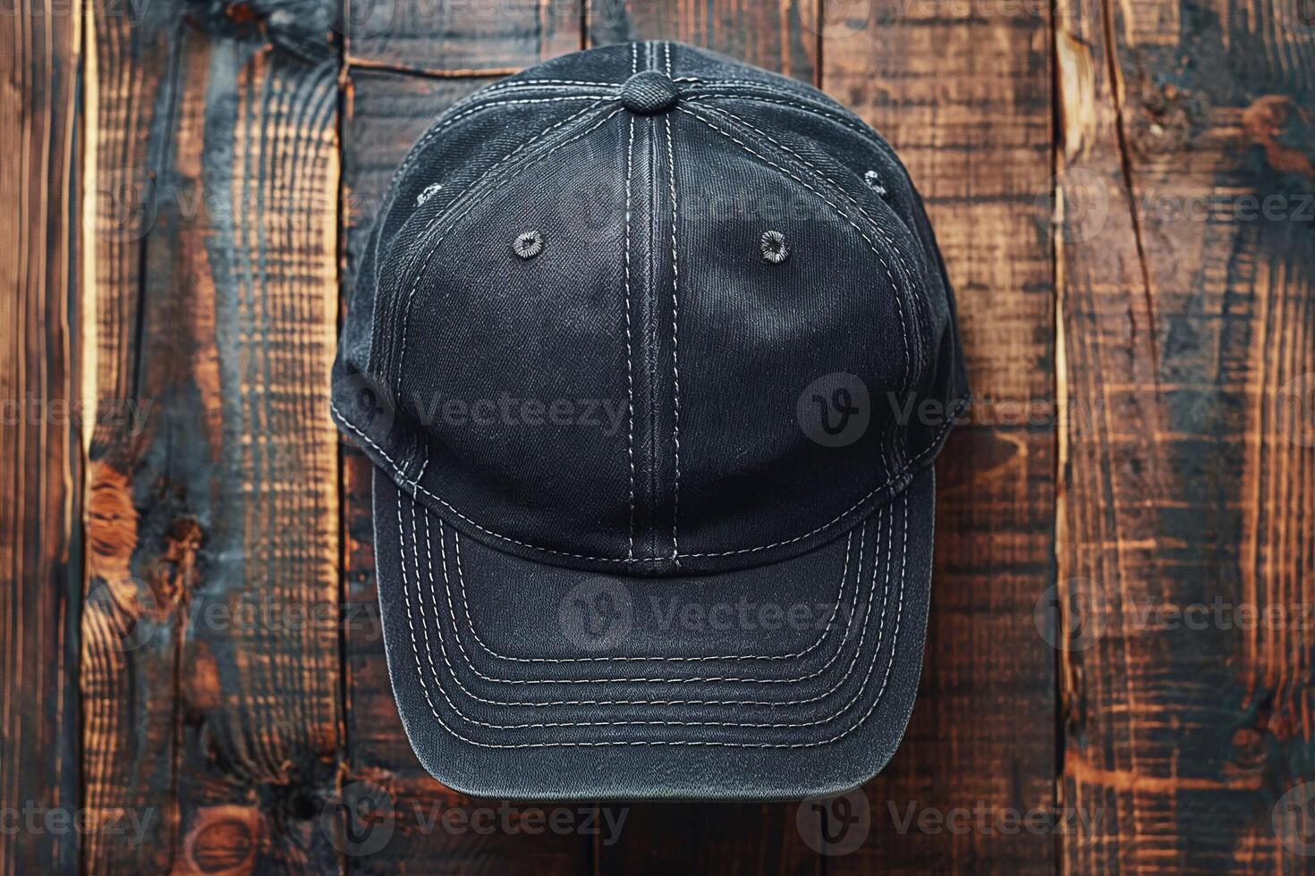 A close-up view of a worn black baseball cap on a rustic wooden surface. photo