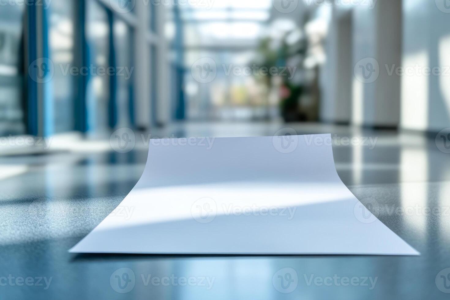 A close-up view of a blank sheet of paper lying on a polished floor in a modern corridor. photo