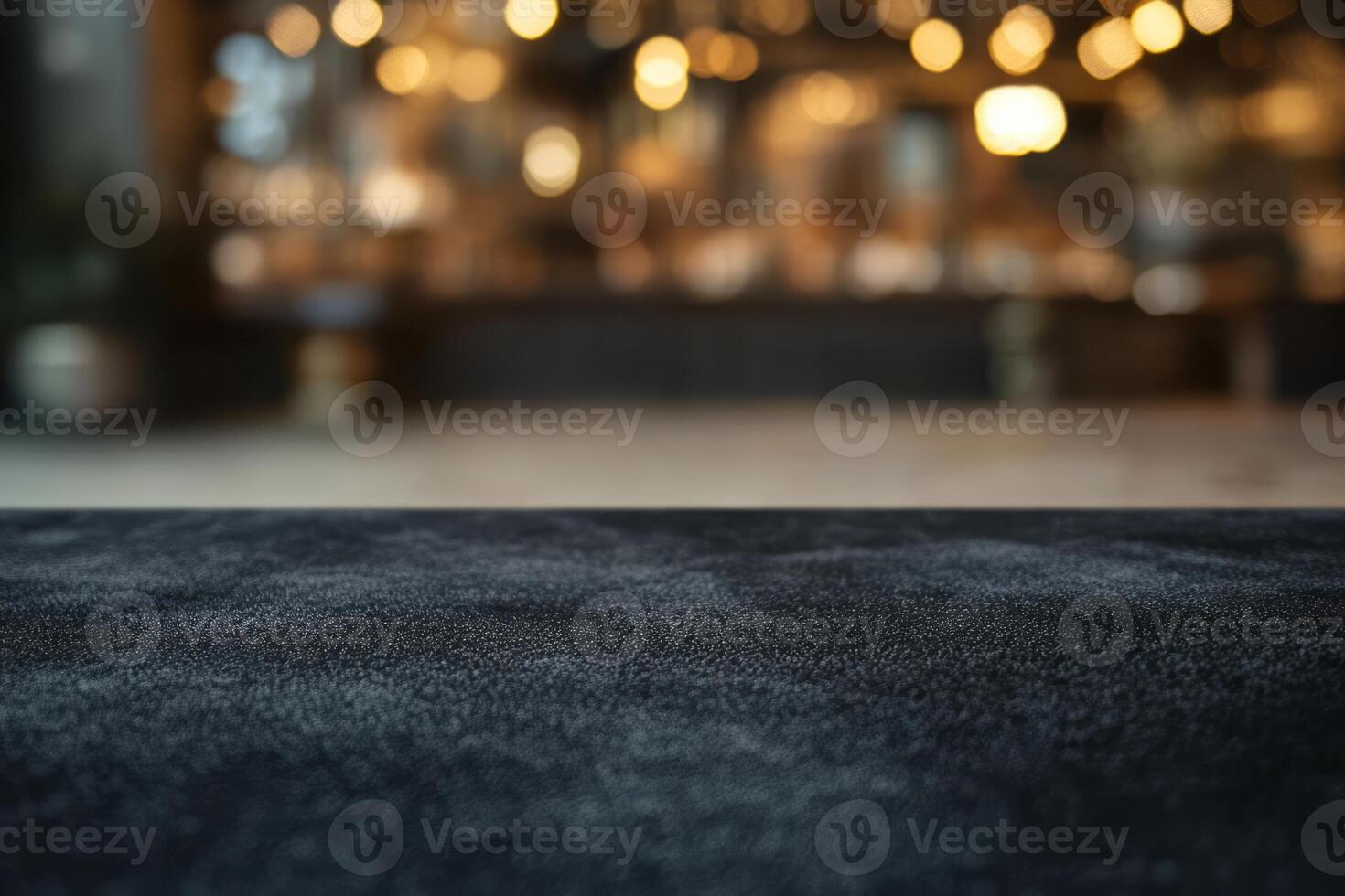 A close-up of a textured dark surface, with a softly blurred background showcasing warm bokeh lights. photo