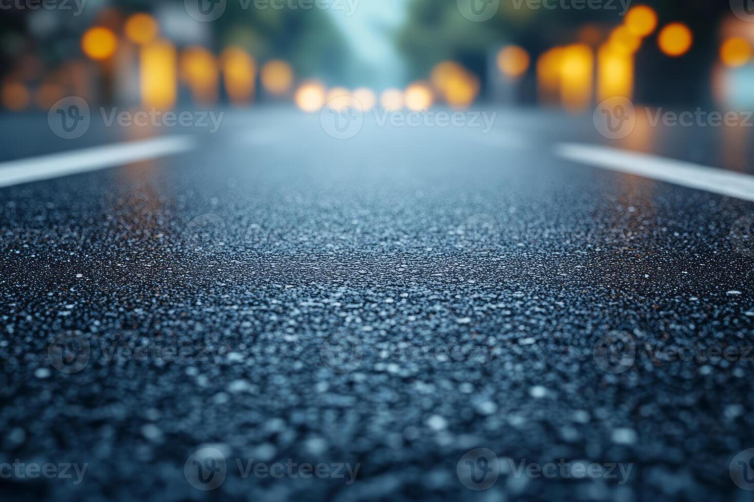 A close-up view of a wet asphalt road, reflecting blurred streetlights, creating a tranquil evening atmosphere. photo