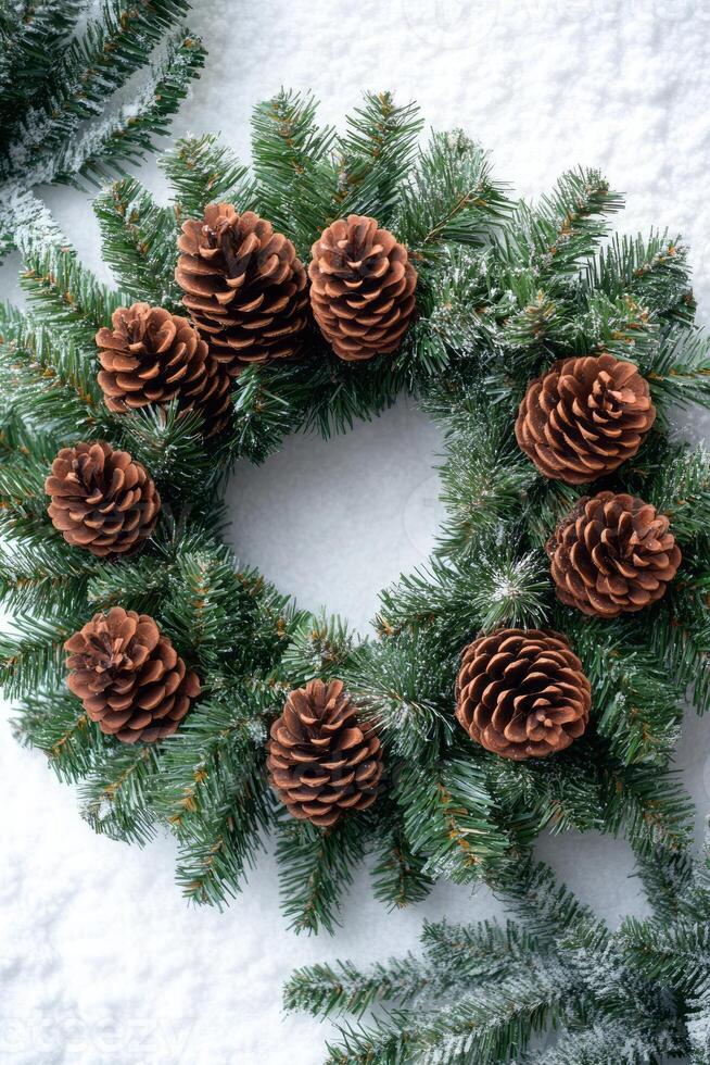 A festive holiday wreath featuring pine cones and lush evergreen branches, set against a backdrop of soft white snow. photo