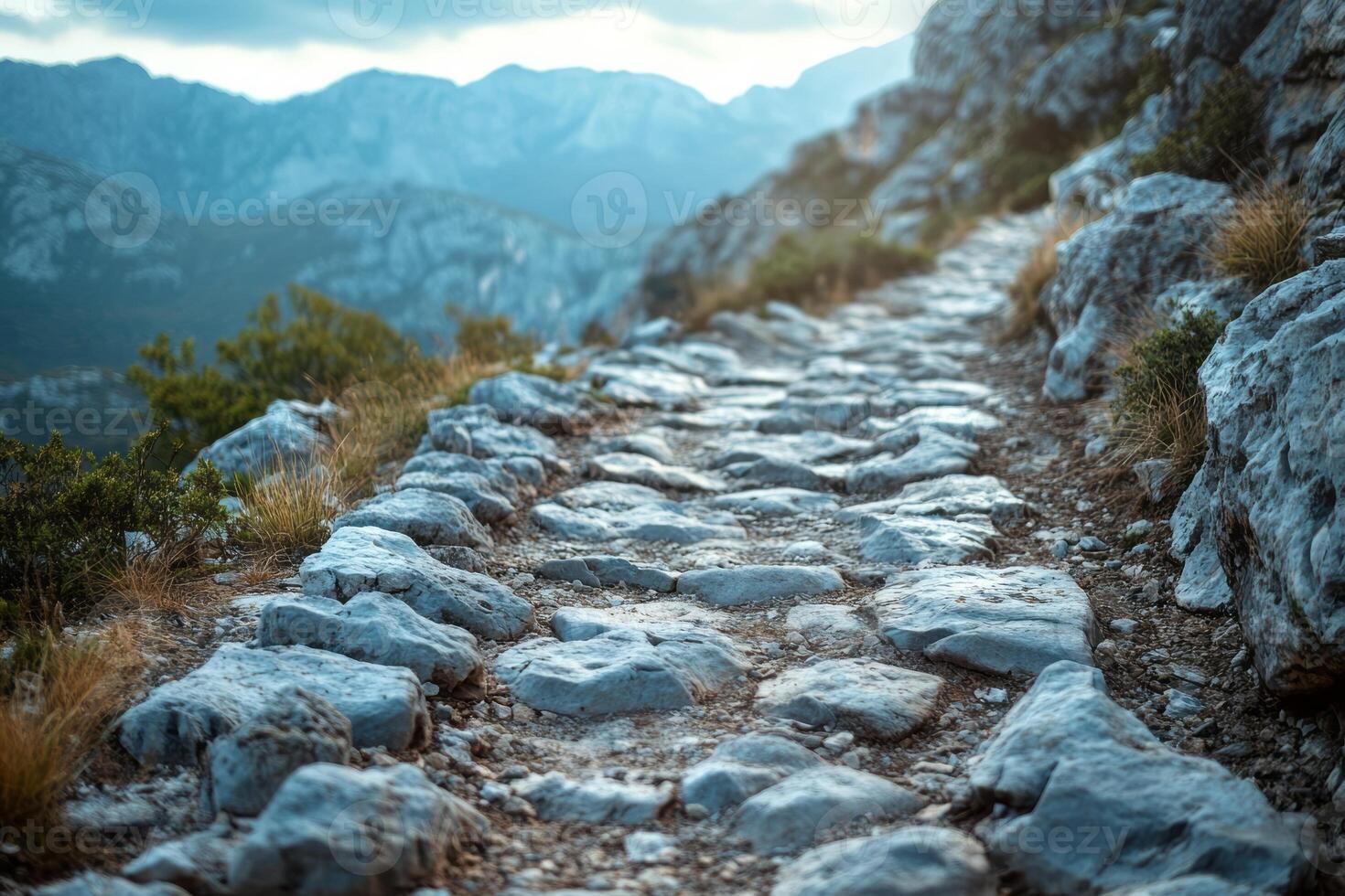 A scenic rocky path winding through mountainous terrain, showcasing natural beauty and serene surroundings. photo