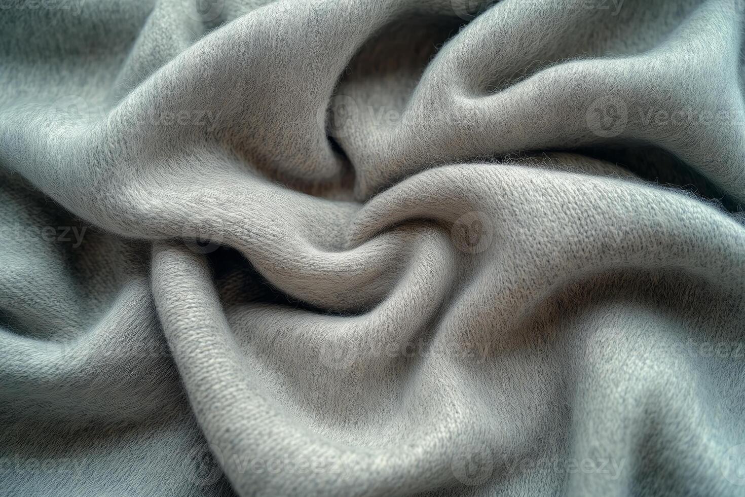 A close-up view of soft, light gray fabric elegantly draped, showcasing its gentle folds and luxurious texture. photo